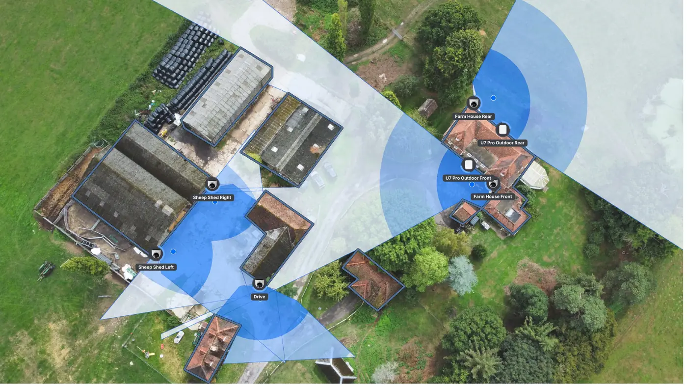 Aerial view of a rural estate with camera fields of view and WiFi coverage marked over the farmhouse, sheds and driveway